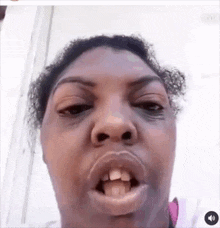 a close up of a woman 's face with her mouth open and her teeth showing .