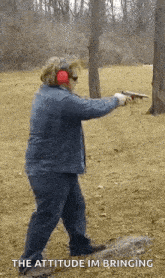 a woman wearing ear muffs is pointing a gun at the camera with the words " the attitude im bringing " below her