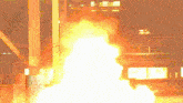 a large amount of fire is coming out of a building at night