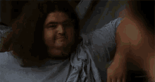 a man with long hair is giving a high five and the words `` that 's fine '' are behind him .