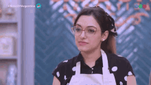 a woman wearing glasses and an apron is on a tv show