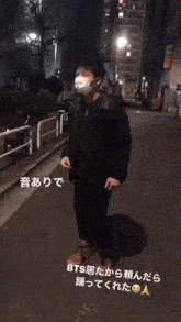 a man wearing a face mask is standing on a sidewalk at night
