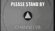 a black and white sign that says `` please stand by channel 98 '' .