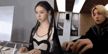 a man and a woman are sitting next to each other in front of a computer .