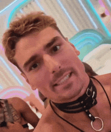 a man is wearing a choker around his neck and smiling