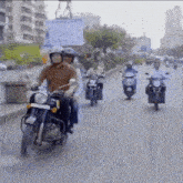 a group of people are riding motorcycles down a street .