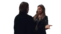 a woman in a black jacket is hugging another woman in a black jacket