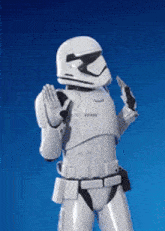 a storm trooper is standing in front of a blue background and giving a thumbs up .
