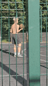 a shirtless man holding a basketball on a court