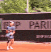 a tennis player is playing in front of a bnp pari banner