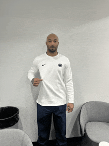 a man wearing a white nike sweatshirt with a penn state logo