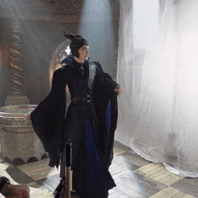 a woman in a costume with horns is standing in a room