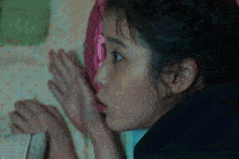 a close up of a woman covering her mouth with her hand