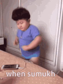 a little boy is dancing on a bed with the words " when sumukh " written below him