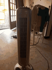 a fan is sitting on a tiled floor in a living room