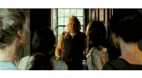 a group of people standing around a man in a room .