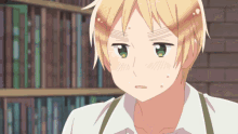 a boy with blonde hair and green eyes is standing in front of bookshelves