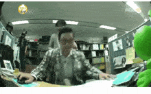 a man is sitting at a desk with a mouse in front of him and a sign that says ' mbc ' on it