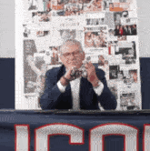 a man in a suit is taking a picture in front of a poster that says ' perfect '