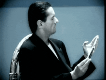 a man in a suit is looking at his phone