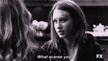 a woman is talking to another woman in a black and white photo and asking her what scares her .