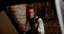 a man in a white shirt is holding a gun