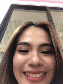 a woman is smiling and looking at the camera