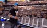 a man wearing a blue hat and sunglasses is running in front of a crowd of people .