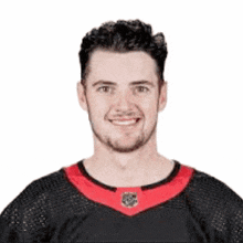 a man with a beard is wearing a black and red shirt