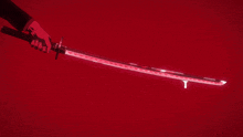 a person is holding a sword with a red glowing blade