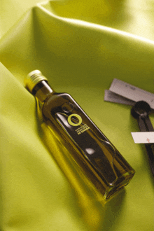 a bottle of extra virgin olive oil sits on a yellow cloth