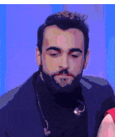 a man with a beard is wearing a suit and a turtleneck sweater .