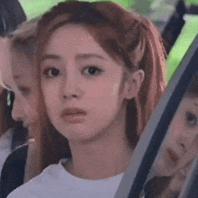 a woman with red hair is sitting in the back seat of a car .