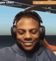 a man wearing headphones is smiling in front of a screen that says ' per chat ' on it