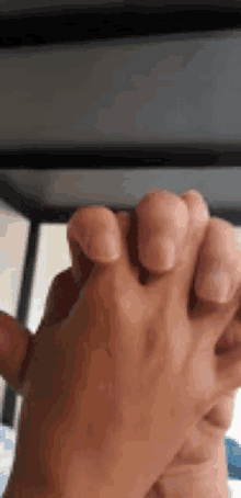 a close up of a person holding another person 's hand with their fingers crossed .
