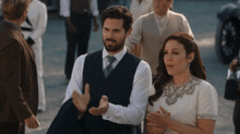 a man and a woman are standing next to each other in a crowd