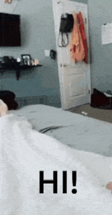 a person is laying on a bed with the words hi written on it
