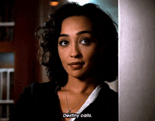 a woman standing next to a wall with the words destiny calls visible