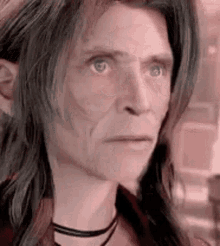 a close up of a person 's face with long hair .