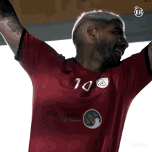a man wearing a red shirt with the number 10 on the front