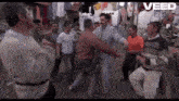 a group of men are dancing in front of a banner that says veed on it