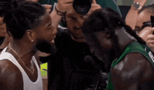 a man taking a picture of a basketball player with dreadlocks