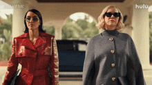 two women standing next to each other with a hulu logo behind them