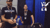a man wearing a battlefield 4 t-shirt is standing next to another man