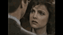 a black and white photo of a woman and a man looking at each other .