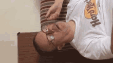 a man wearing glasses and a hard rock t-shirt is laying down on a couch .