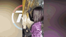 a girl in a purple shirt is standing next to a tree with the number 7 in the corner