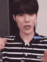 a young man wearing a black and white striped shirt with the word flower on the sleeve