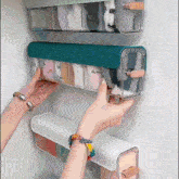 a person is reaching into a clear container with a blue lid that says ' socks ' on it