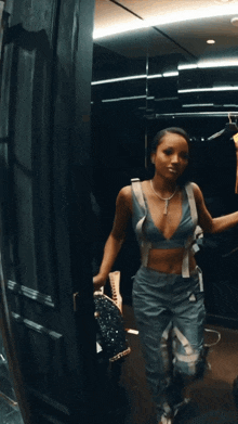 a woman in a blue crop top and suspenders is standing in a closet
